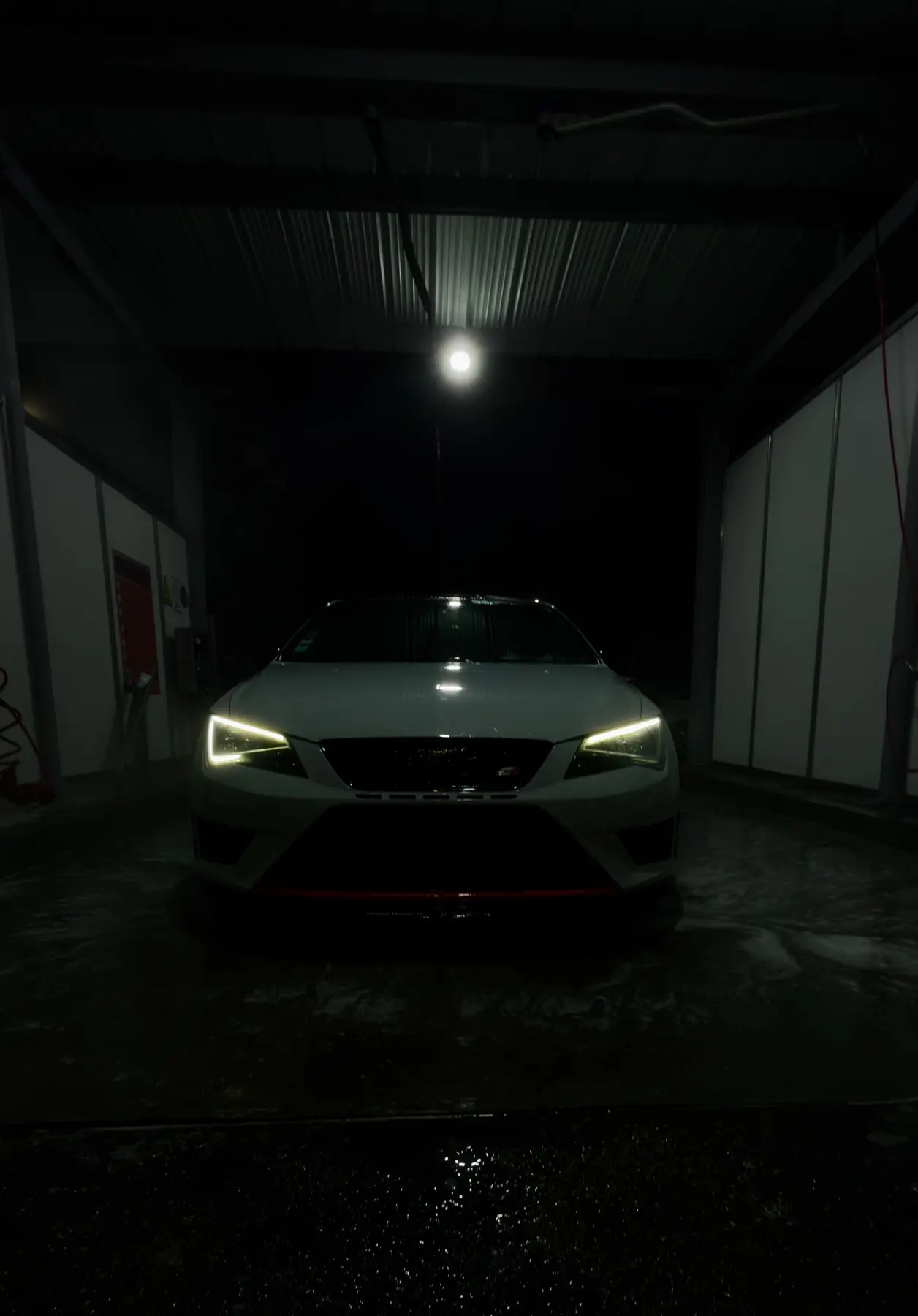 Cupra photographiée de nuit en station de lavage